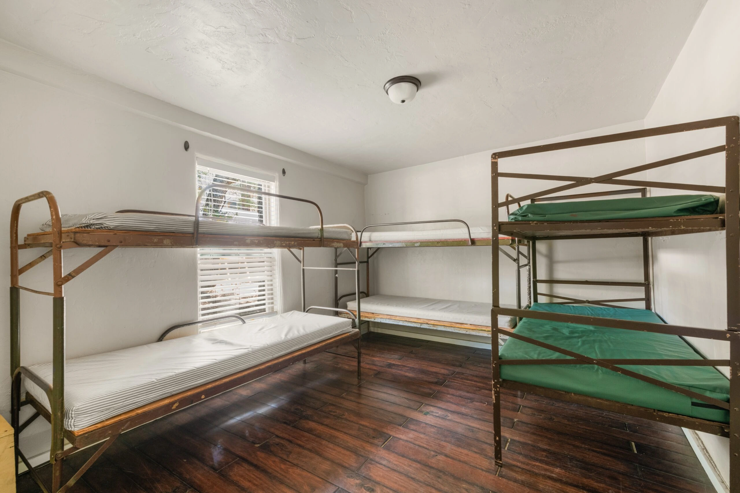 a room with bunk beds and a wood floor