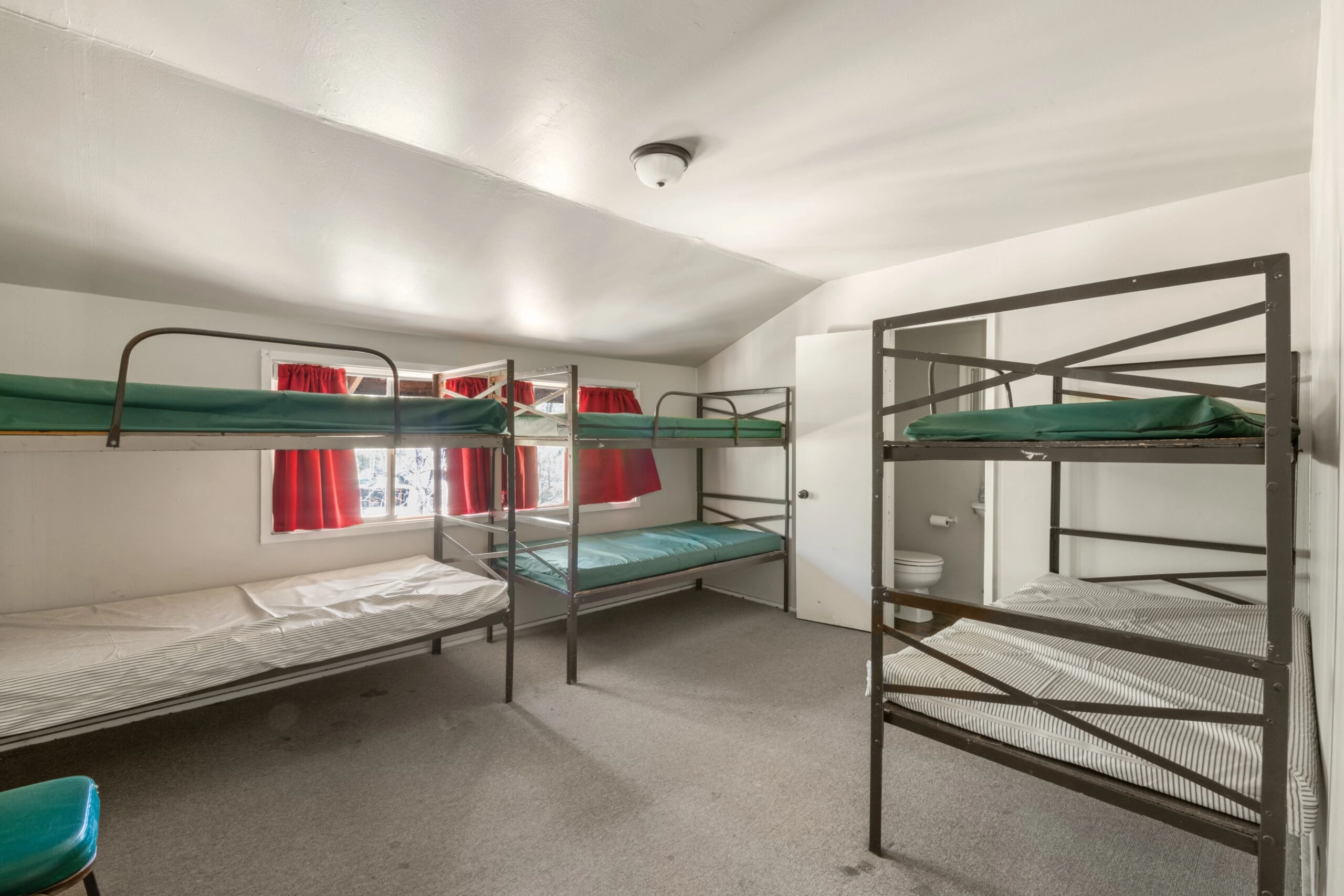 a room with bunk beds and red curtains