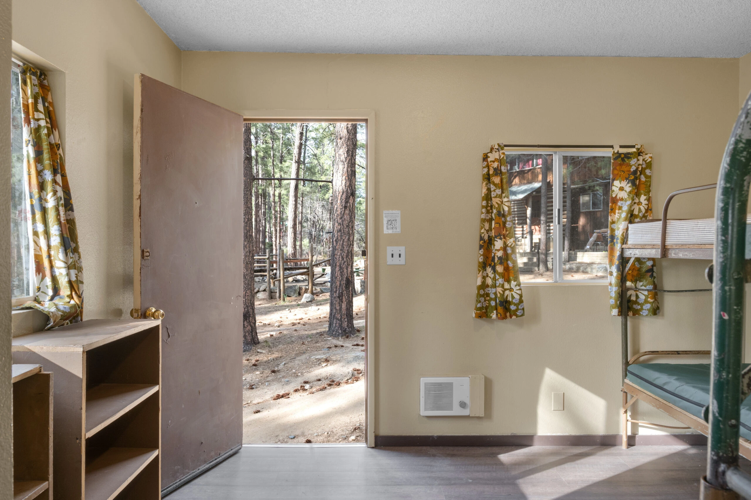 a room with a door open and a window with trees outside