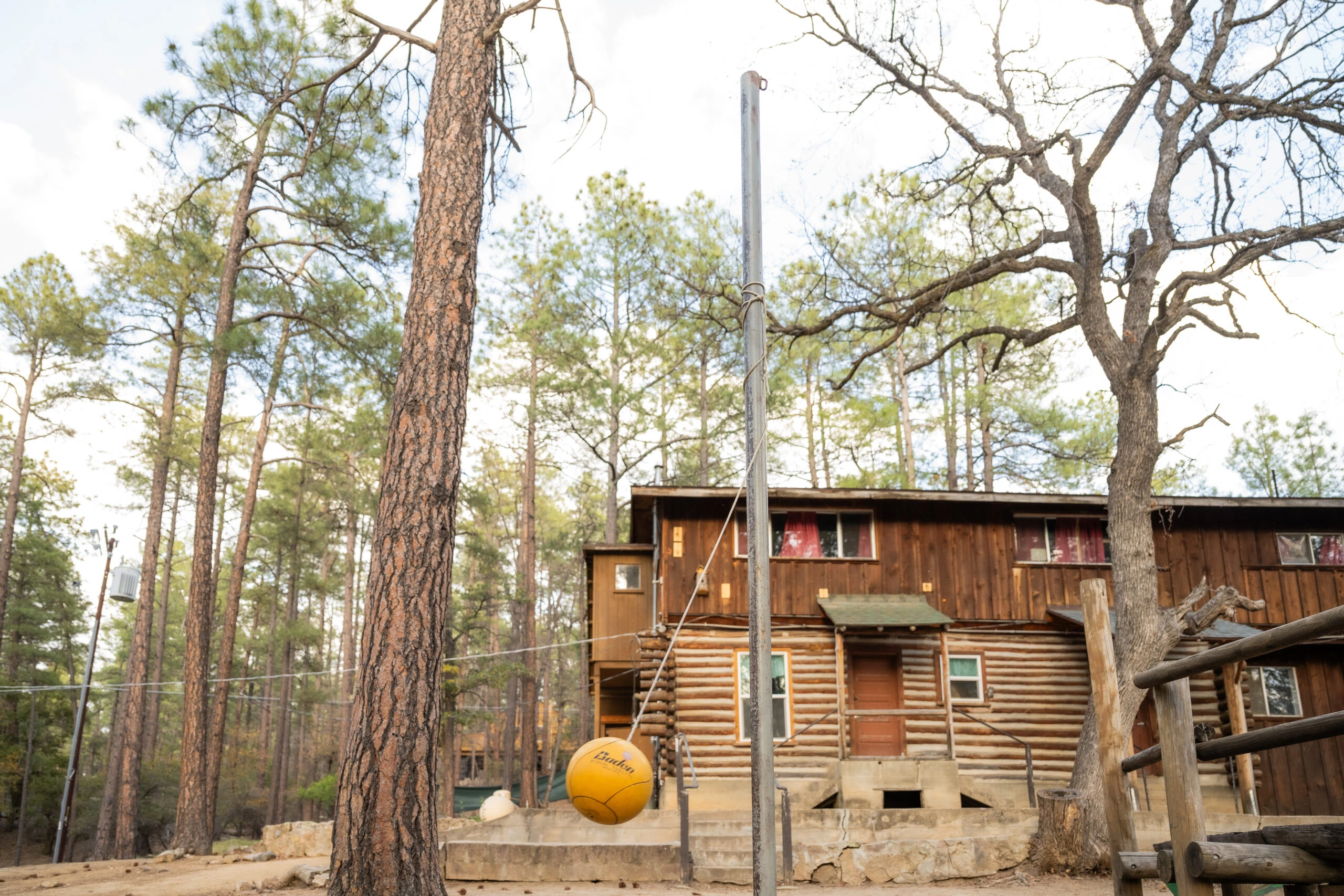 a yellow ball from a pole in front of a log cabin