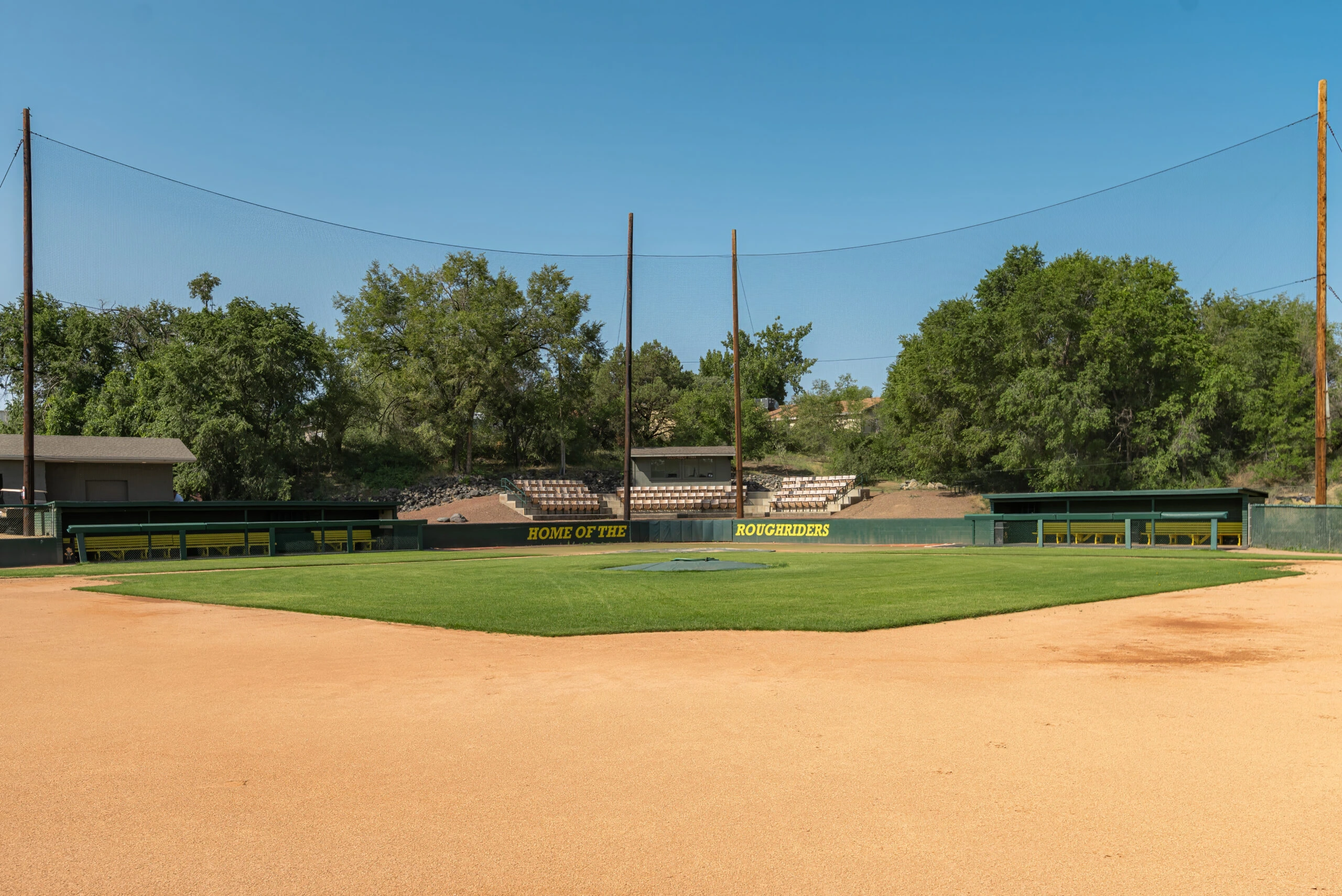 a baseball field with trees in the background