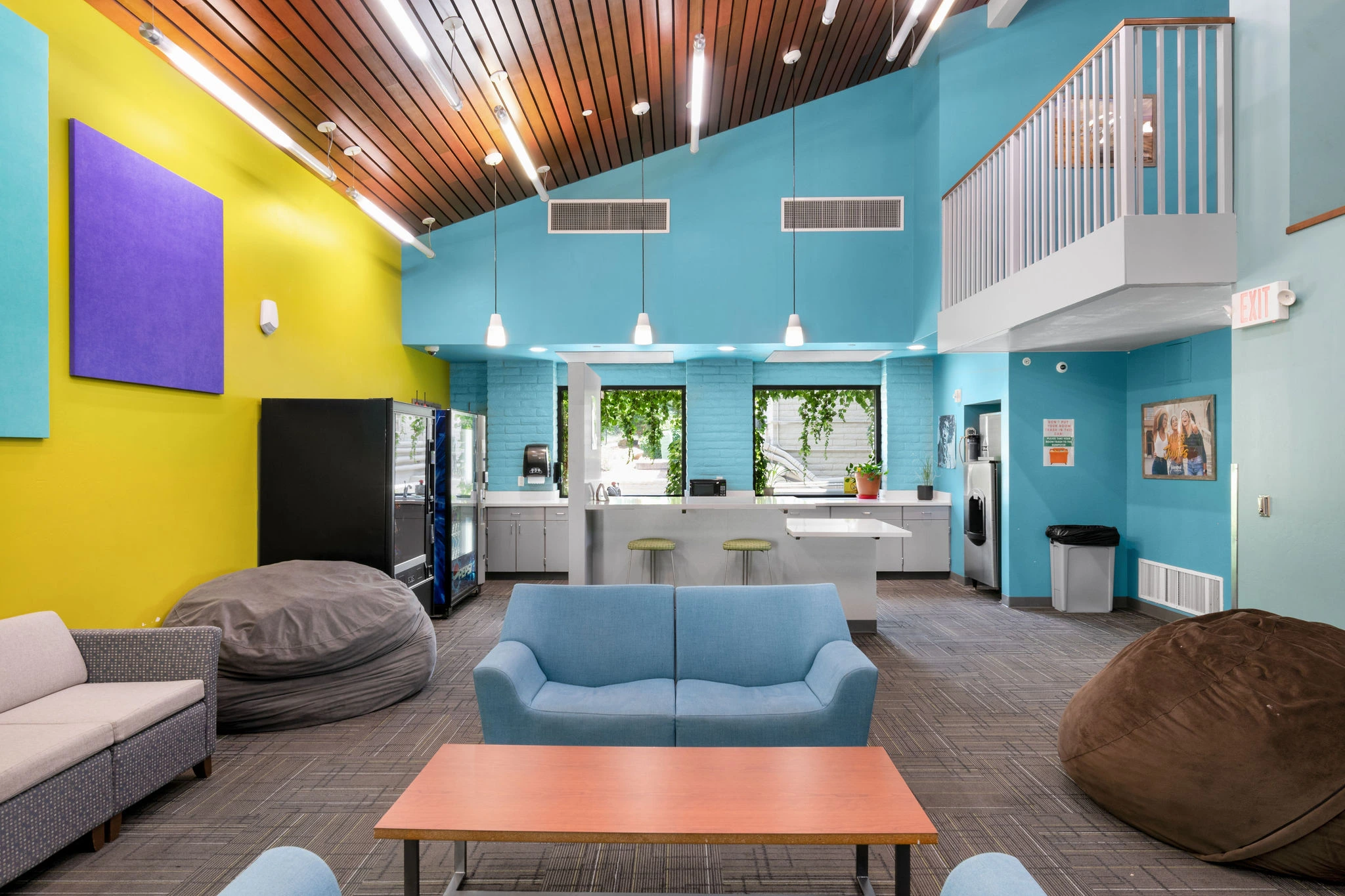 a room with blue couches and a yellow wall