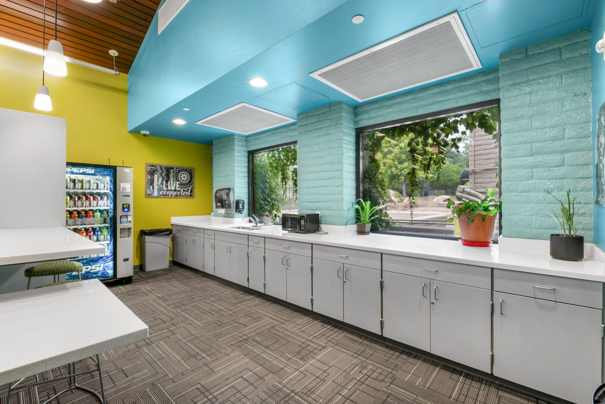 a room with a blue and yellow wall and white cabinets