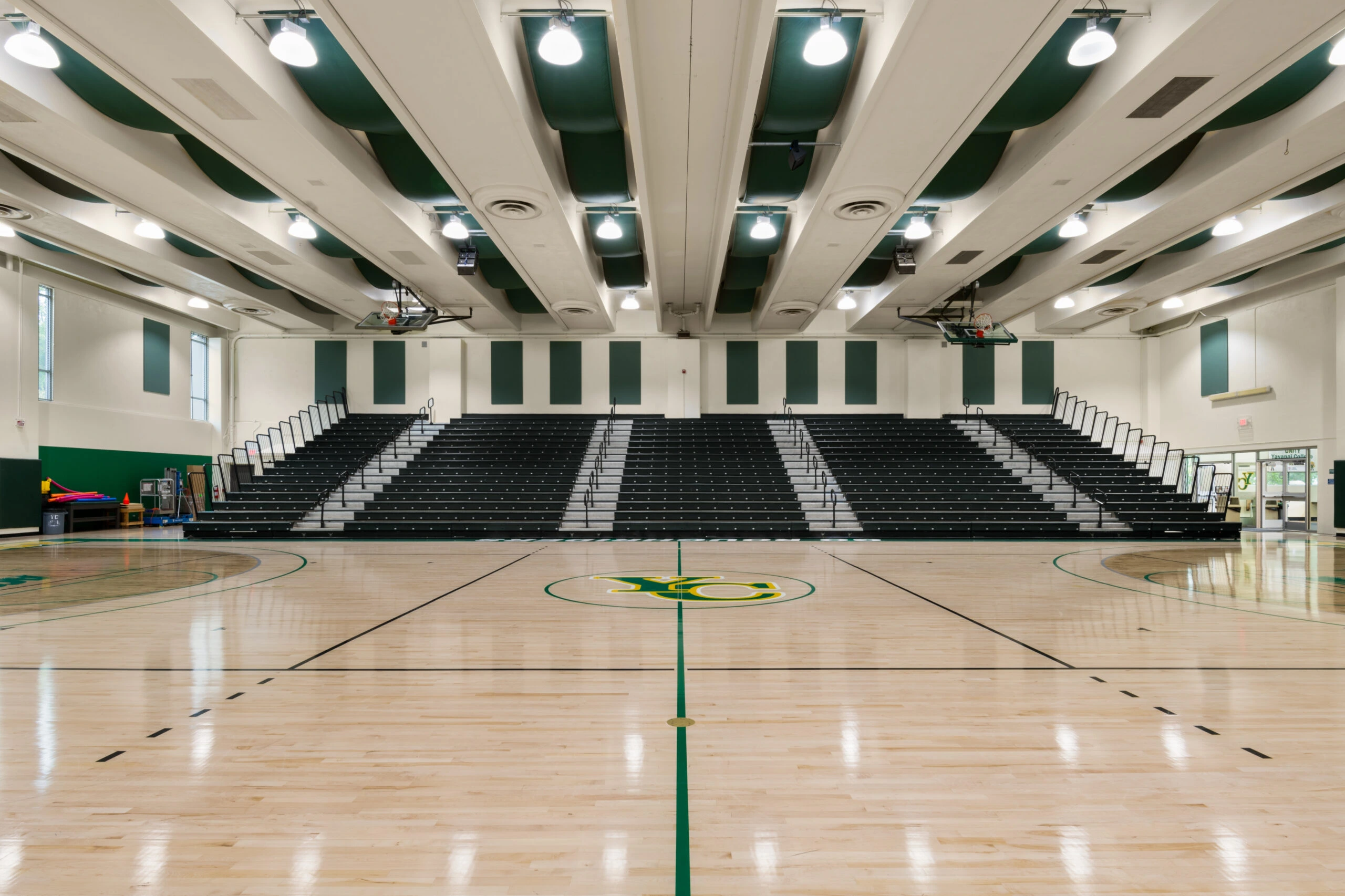a basketball court with green seats and green and white walls