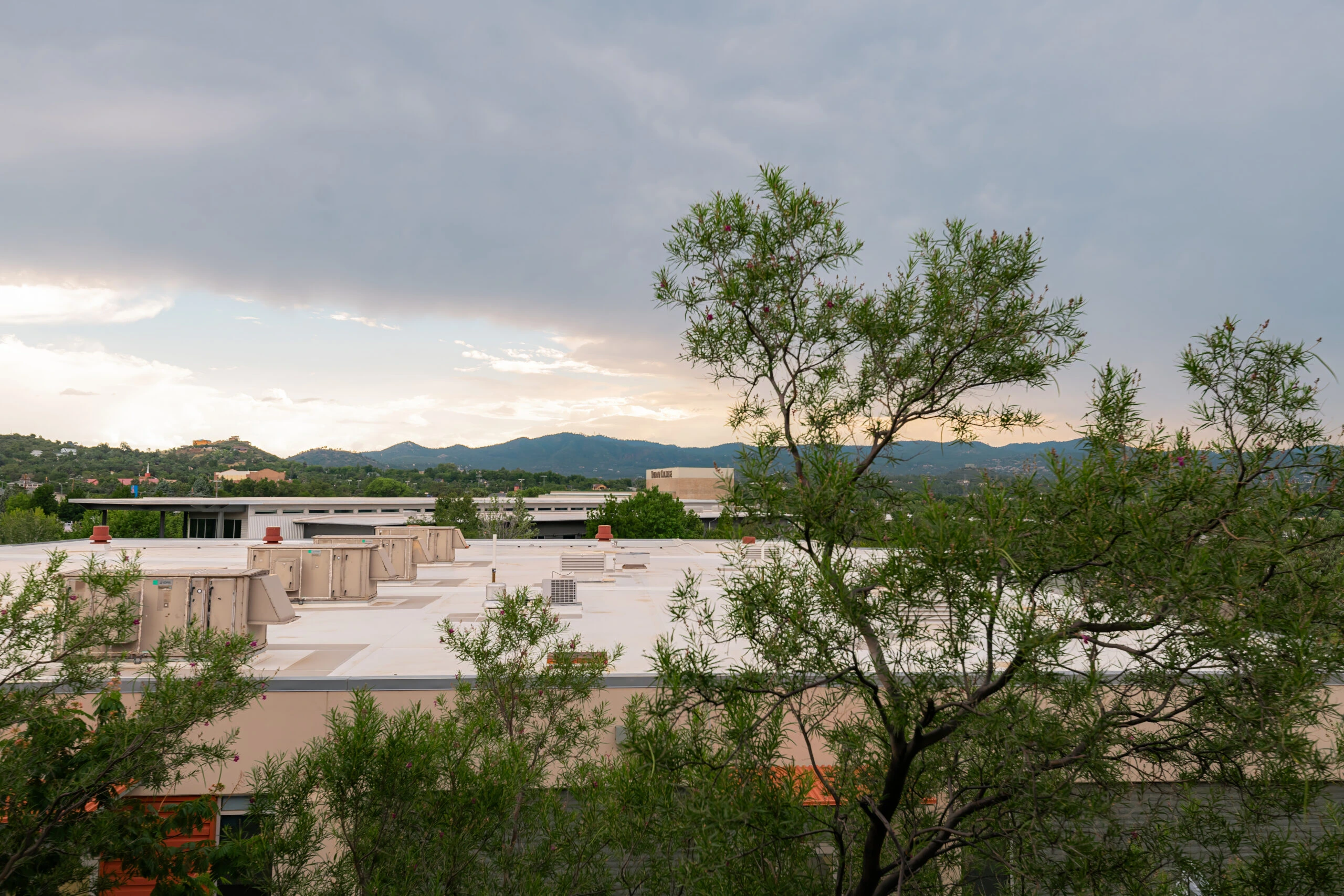 a building with trees and mountains in the background