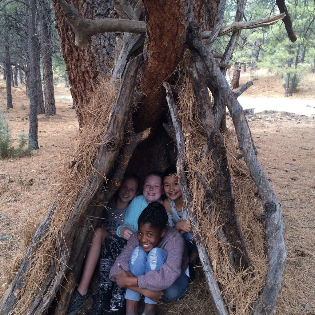a group of kids sitting in a teepee