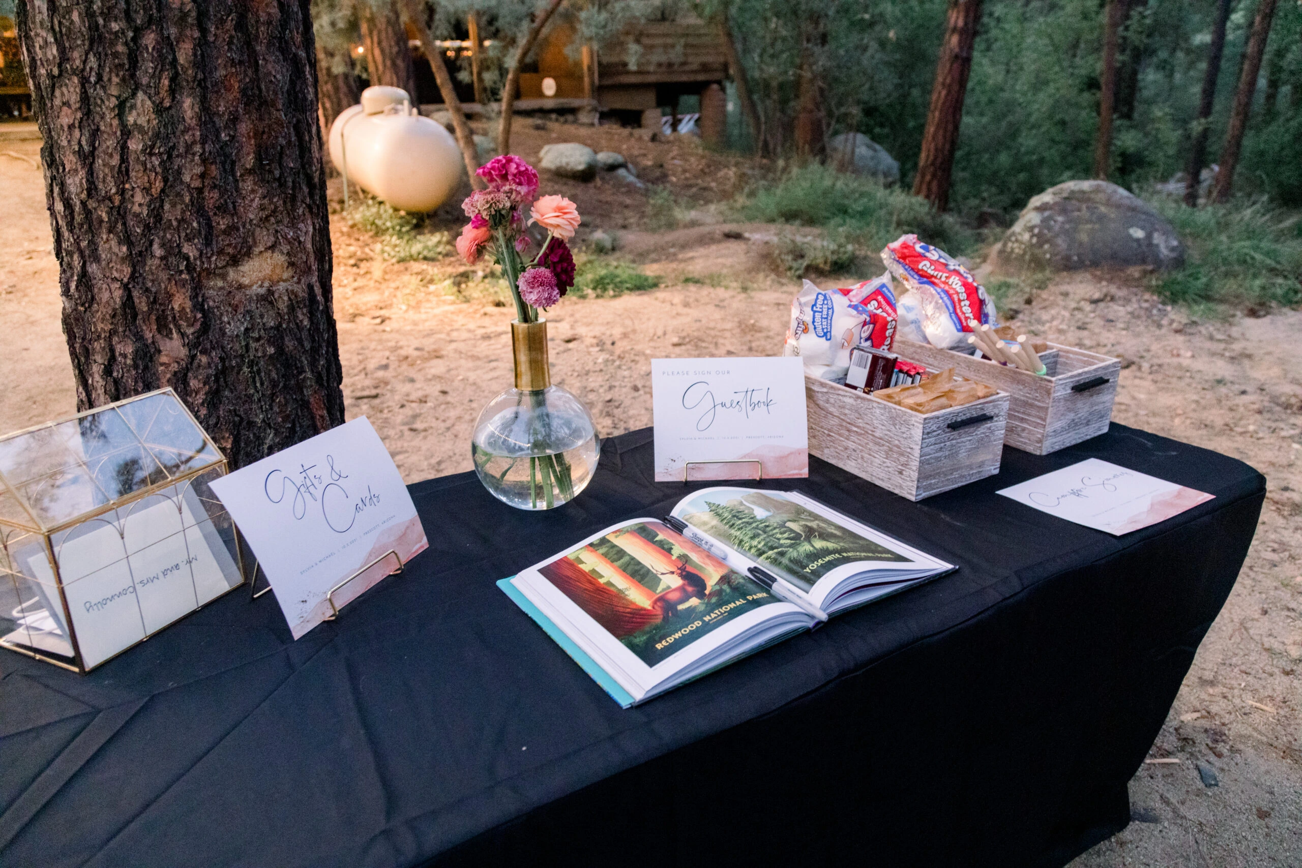 a table with a vase of flowers and books
