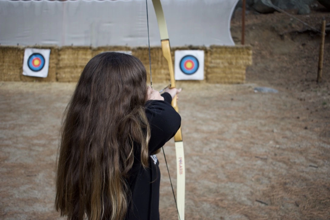 a girl aiming a bow and arrow