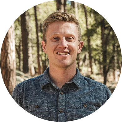 a man smiling in a forest