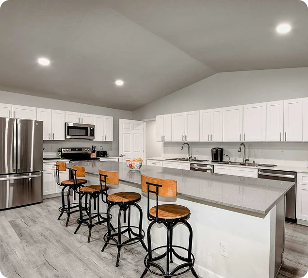 a kitchen with a large island and a stainless steel refrigerator