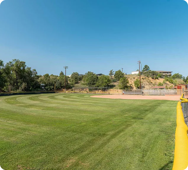 a baseball field with a yellow fence