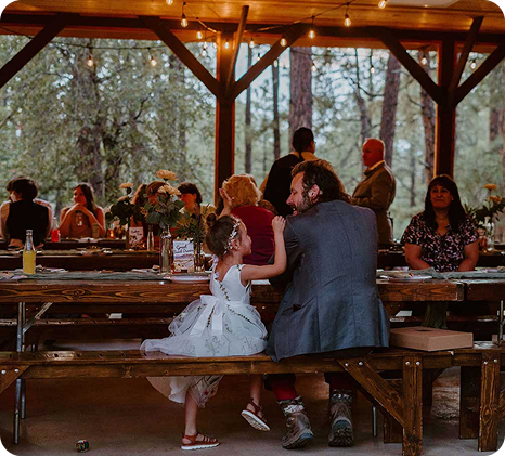a man and a girl sitting at a picnic table