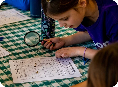 a girl looking at a magnifying glass