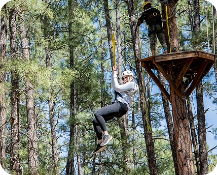 a woman in a white helmet from a rope in the air