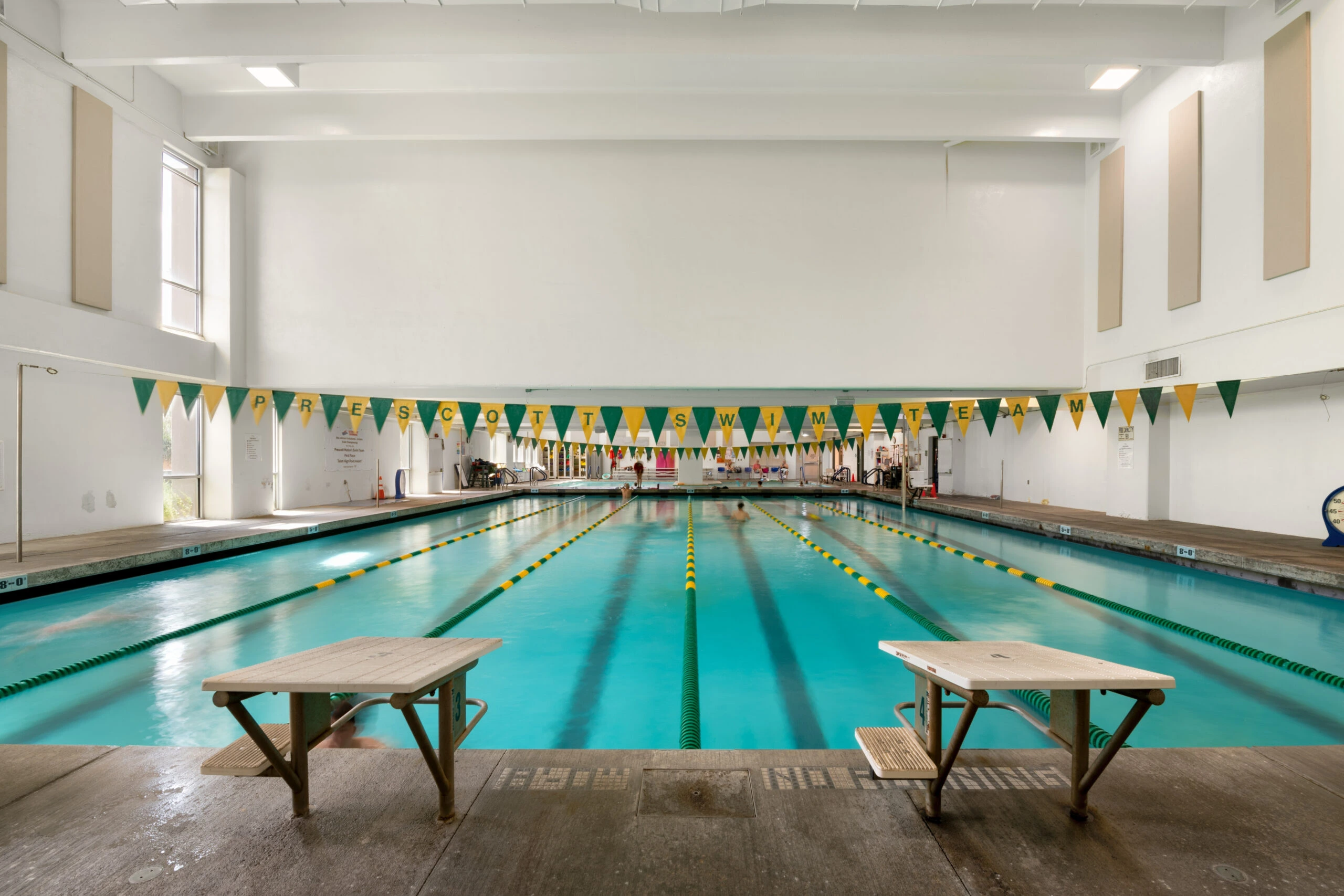 a swimming pool with benches and flags