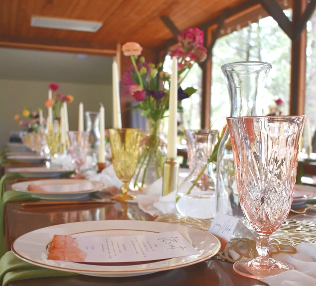 a table with plates and glasses and flowers
