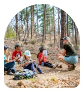a group of children sitting in the woods