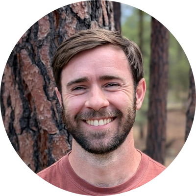 man smiling with trees in background